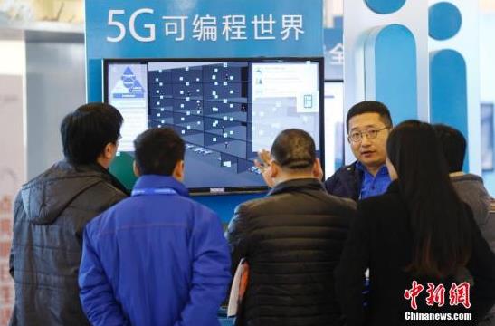 资料图：参观者在“互联网之光”博览会上听取参展商介绍“5G可编程世界”。中新社记者盛佳鹏摄